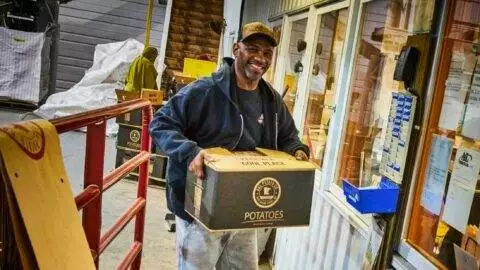 A & L Potato Co. – Man carrying a box of packaged potatoes