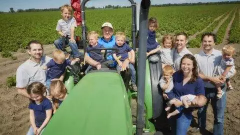 Wysocki Family of Companies family crowded around tractor with Grandpa