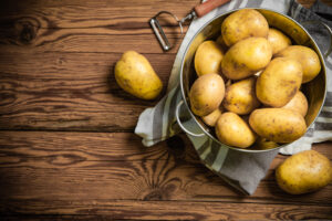 Fresh potatoes. On a wooden table.