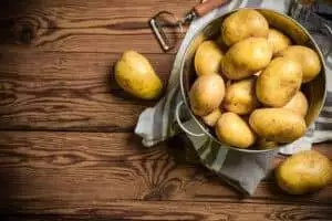 Fresh potatoes. On a wooden table.