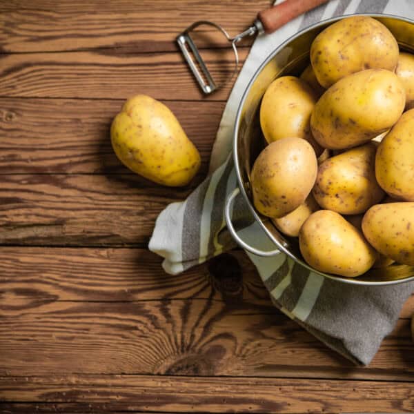 Fresh potatoes. On a wooden table.